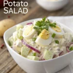 Hellmann's potato salad recipe served in a white bowl, garnished with sliced hard-boiled eggs, red onions, green bell peppers, and fresh parsley.